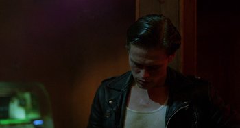 Movie still from “The Loveless” (1981), directed by Kathryn Bigelow – A man in a leather jacket looking down at his hair; Close Up shot, Over the shoulder angle