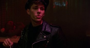 Movie still from “The Loveless” (1981), directed by Kathryn Bigelow – A man wearing a leather jacket and a hat; Close Up shot, Low angle