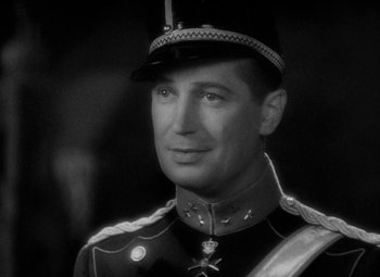 Movie still from “The Merry Widow” (1934), directed by Ernst Lubitsch – A black and white photo of a man in a uniform; Close Up shot, Over the shoulder angle