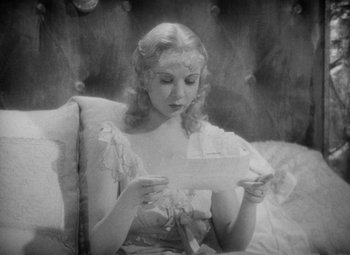 Movie still from “The Merry Widow” (1934), directed by Ernst Lubitsch – A woman sitting on a couch holding a piece of paper; Close Up shot, High angle