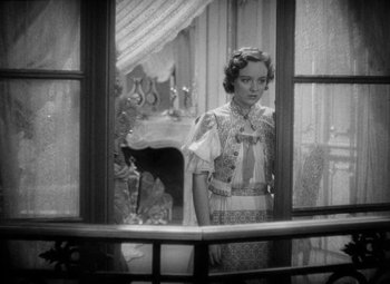 Movie still from “The Merry Widow” (1934), directed by Ernst Lubitsch – A woman standing in front of an open window; Medium shot, High angle
