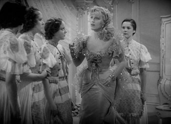 Movie still from “The Merry Widow” (1934), directed by Ernst Lubitsch – A group of women standing next to each other in front of a mirror; Medium shot, Low angle