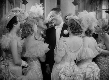 Movie still from “The Merry Widow” (1934), directed by Ernst Lubitsch – A group of people dressed up for a formal event; Medium shot, High angle