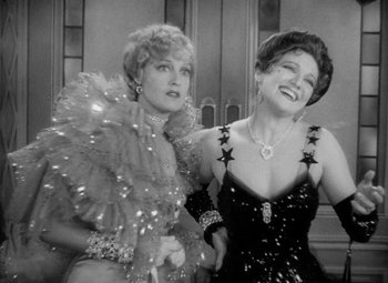 Movie still from “The Merry Widow” (1934), directed by Ernst Lubitsch – Two women are posing for a picture together; Medium shot, Low angle