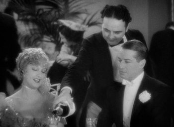 Movie still from “The Merry Widow” (1934), directed by Ernst Lubitsch – A man pouring champagne into a woman's hand; Medium shot, High angle