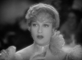 Movie still from “The Merry Widow” (1934), directed by Ernst Lubitsch – An old black and white photo of a woman in a dress; Close Up shot, Over the shoulder angle