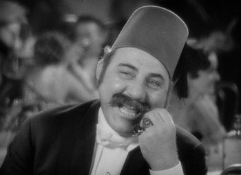 Movie still from “The Merry Widow” (1934), directed by Ernst Lubitsch – A man with a mustache and a fez; Close Up shot, High angle