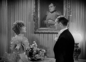 Movie still from “The Merry Widow” (1934), directed by Ernst Lubitsch – A man and a woman standing in front of a painting; Medium shot, Over the shoulder angle
