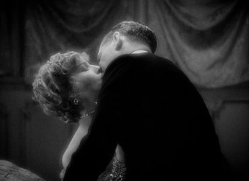 Movie still from “The Merry Widow” (1934), directed by Ernst Lubitsch – A black and white photo of a man and a woman kissing; Close Up shot, Low angle