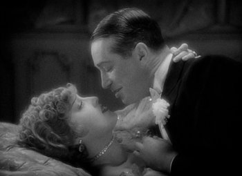 Movie still from “The Merry Widow” (1934), directed by Ernst Lubitsch – A man and a woman kissing in a black and white photo; Close Up shot, High angle