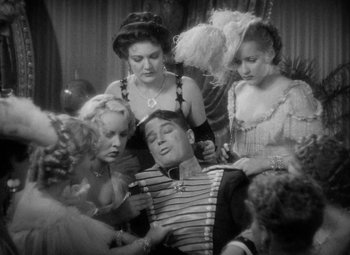 Movie still from “The Merry Widow” (1934), directed by Ernst Lubitsch – A group of women surrounding a man in a striped shirt; Medium shot, High angle