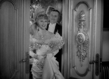 Movie still from “The Merry Widow” (1934), directed by Ernst Lubitsch – A man and a woman standing in front of a door; Medium shot, High angle