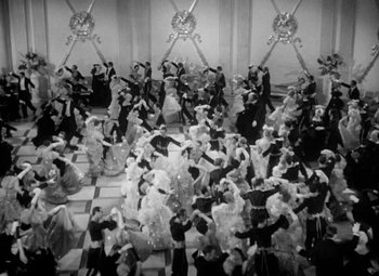 Movie still from “The Merry Widow” (1934), directed by Ernst Lubitsch – A black - and - white photo of people dressed in formal wear; Extreme Wide shot, High angle