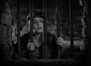 Movie still from “The Merry Widow” (1934), directed by Ernst Lubitsch – A black and white photo of a woman behind bars; Close Up shot, High angle