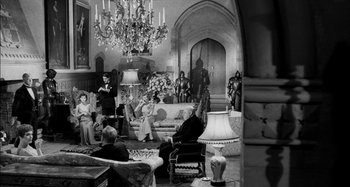 Movie still from “The Mirror Crack'd” (1980), directed by Guy Hamilton – A black and white photo of people sitting in a living room; Wide shot, High angle