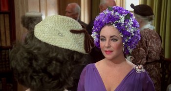 Movie still from “The Mirror Crack'd” (1980), directed by Guy Hamilton – A person wearing a purple dress; Close Up shot, Over the shoulder angle