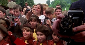 Movie still from “The Mirror Crack'd” (1980), directed by Guy Hamilton – A group of people taking pictures of a crowd of people; Medium shot, High angle