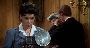 Movie still from “The Mirror Crack'd” (1980), directed by Guy Hamilton – An old fashioned woman holding an old fashioned camera; Close Up shot, Over the shoulder angle
