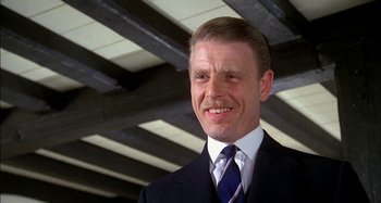 Movie still from “The Mirror Crack'd” (1980), directed by Guy Hamilton – A person wearing a suit and tie; Close Up shot, Low angle