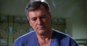 Movie still from “The Mirror Crack'd” (1980), directed by Guy Hamilton – An older man in a blue sweater looking sad; Close Up shot, Low angle