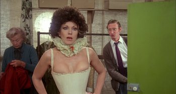 Movie still from “The Mirror Crack'd” (1980), directed by Guy Hamilton – A man and a woman standing next to each other in a room; Medium shot, Over the shoulder angle