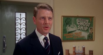 Movie still from “The Mirror Crack'd” (1980), directed by Guy Hamilton – A person wearing a suit and a tie; Close Up shot, Low angle