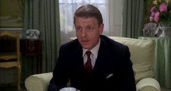 Movie still from “The Mirror Crack'd” (1980), directed by Guy Hamilton – A person wearing a suit and tie; Close Up shot, High angle