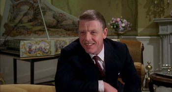 Movie still from “The Mirror Crack'd” (1980), directed by Guy Hamilton – A man in a suit sitting in front of a piano; Close Up shot, Low angle