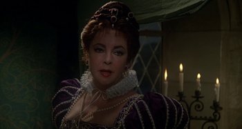 Movie still from “The Mirror Crack'd” (1980), directed by Guy Hamilton – A person wearing a costume; Close Up shot, Over the shoulder angle