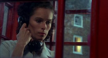 Movie still from “The Mirror Crack'd” (1980), directed by Guy Hamilton – A woman with headphones is looking out of a window; Close Up shot, Low angle