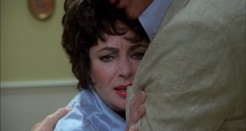 Movie still from “The Mirror Crack'd” (1980), directed by Guy Hamilton – A woman is holding on to a man's arm; Close Up shot, Over the shoulder angle