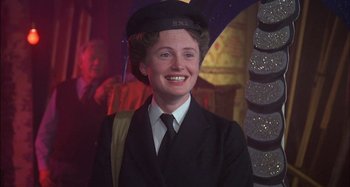 Movie still from “The Mirror Crack'd” (1980), directed by Guy Hamilton – A woman in a suit and hat smiling for the camera; Close Up shot, Low angle