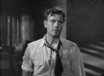 Movie still from “The Most Dangerous Game” (1932), directed by Irving Pichel – A black and white photo of a man wearing a shirt and tie; Close Up shot, Over the shoulder angle