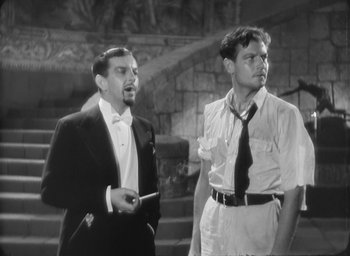 Movie still from “The Most Dangerous Game” (1932), directed by Irving Pichel – Two men standing next to each other in front of a stone wall; Medium shot, Low angle