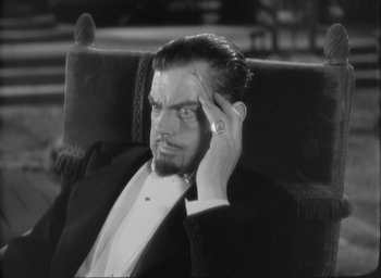 Movie still from “The Most Dangerous Game” (1932), directed by Irving Pichel – A black and white photo of a man in a suit and tie; Close Up shot, High angle