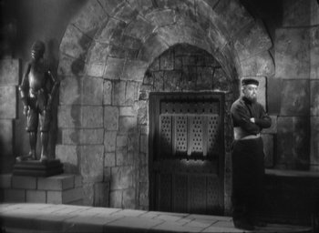 Movie still from “The Most Dangerous Game” (1932), directed by Irving Pichel – A man standing in front of an arched doorway; Wide shot, Low angle