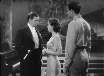 Movie still from “The Most Dangerous Game” (1932), directed by Irving Pichel – Two men and a woman standing next to each other in front of a staircase; Medium shot, High angle