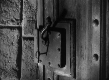 Movie still from “The Most Dangerous Game” (1932), directed by Irving Pichel – A black - and - white photo of a door with a lock; Extreme Close Up shot, High angle