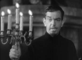 Movie still from “The Most Dangerous Game” (1932), directed by Irving Pichel – A man holding a candelabrum with four lit candles in front of him; Medium shot, Low angle