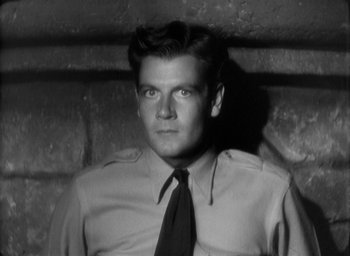 Movie still from “The Most Dangerous Game” (1932), directed by Irving Pichel – Black and white photograph of a man wearing a shirt and tie; Close Up shot, High angle