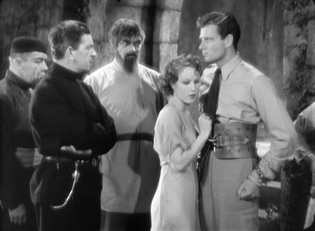 Movie still from “The Most Dangerous Game” (1932), directed by Irving Pichel – A group of people standing around each other in front of a building; Medium shot, Over the shoulder angle