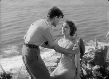 Movie still from “The Most Dangerous Game” (1932), directed by Irving Pichel – A man and a woman standing next to each other on the beach; Medium shot, High angle