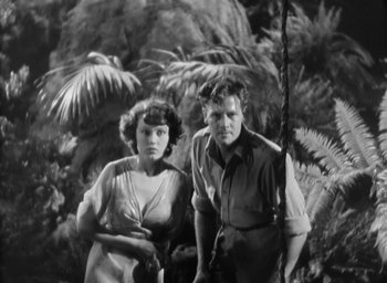 Movie still from “The Most Dangerous Game” (1932), directed by Irving Pichel – A man and a woman standing next to each other in front of trees; Medium shot, Low angle