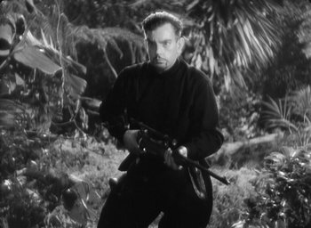 Movie still from “The Most Dangerous Game” (1932), directed by Irving Pichel – A black and white photo of a man holding a rifle; Medium shot, Low angle