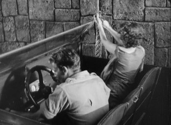 Movie still from “The Most Dangerous Game” (1932), directed by Irving Pichel – A man and a woman in the back of an old car; Medium shot, High angle