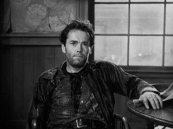 Movie still from “The Ox-Bow Incident” (1942), directed by William A. Wellman – Black and white photograph of a man sitting in a chair; Medium shot, Low angle