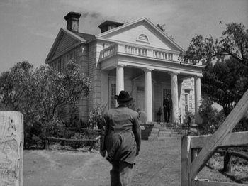 Movie still from “The Ox-Bow Incident” (1942), directed by William A. Wellman – An old photo of a man walking in front of a house; Wide shot, Low angle