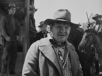 Movie still from “The Ox-Bow Incident” (1942), directed by William A. Wellman – An old photo of a man in a cowboy hat; Medium shot, Over the shoulder angle