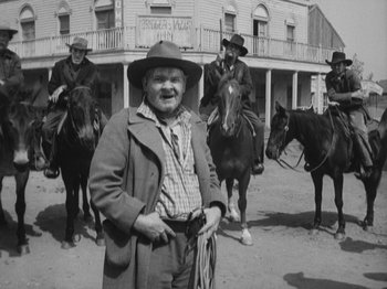Movie still from “The Ox-Bow Incident” (1942), directed by William A. Wellman – An old photo of a man and two men on horses; Medium shot, Low angle