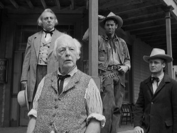 Movie still from “The Ox-Bow Incident” (1942), directed by William A. Wellman – An old photo of a group of men standing on a porch; Medium shot, Low angle